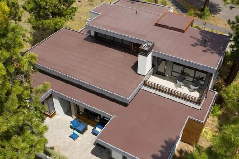 Aerial view of a modern home with a flat roof and patio