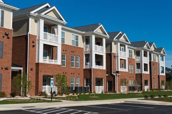 Three-story brick multi-family apartment building with balconies