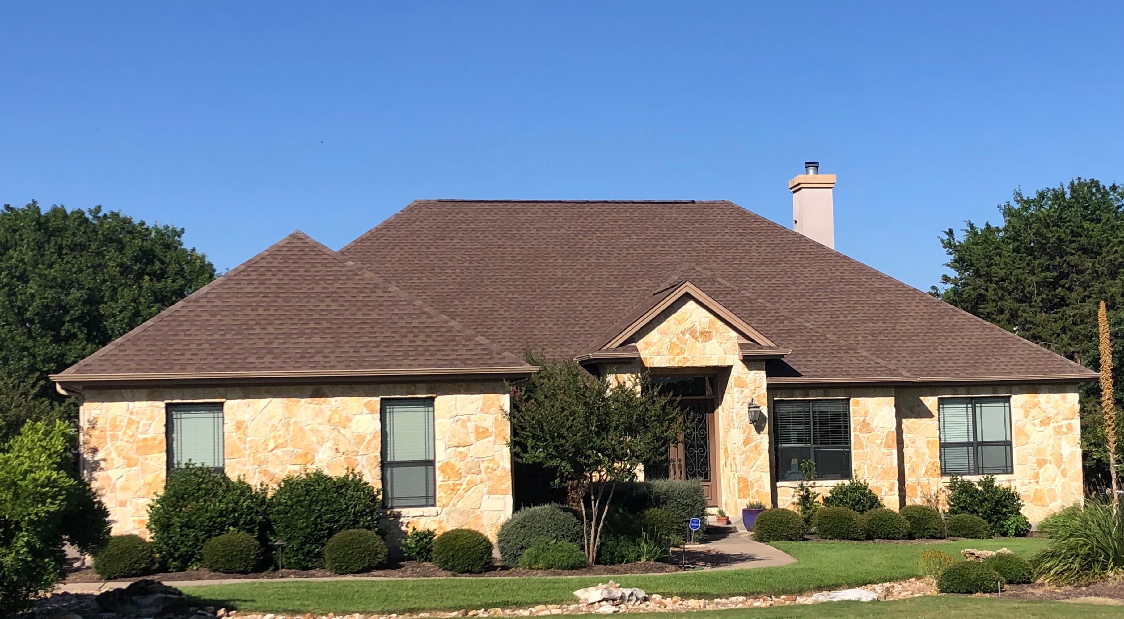 Architectural shingle roof on a single-story stone home