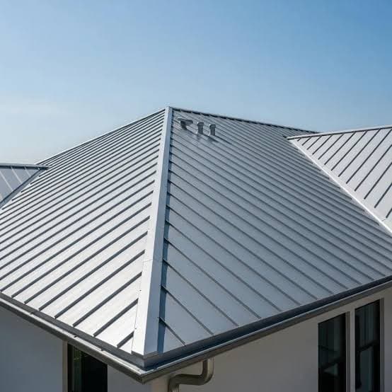 Close-up aerial view of a silver standing seam metal hip roof