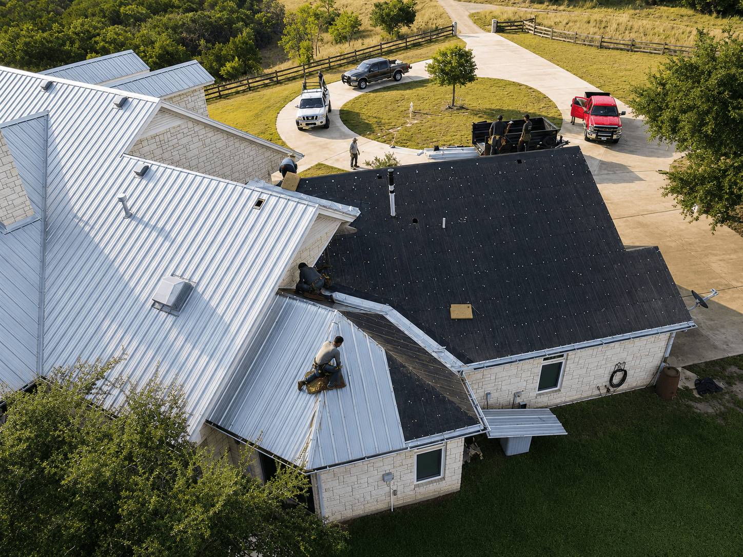 Aerial view of a crew installing a standing seam metal roof on a Hill Country home